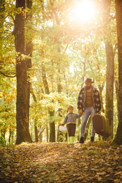 Πατέρας και γιος παίζουν στο φθινοπωρινό δάσος. Πατέρας και γιος περπατούν μαζί στο πάρκο, την φθινοπωρινή μέρα. Άντρας με μούσι, πατέρας με μικρό γιο στο πάρκο του φθινοπώρου. — Φωτογραφία Αρχείου