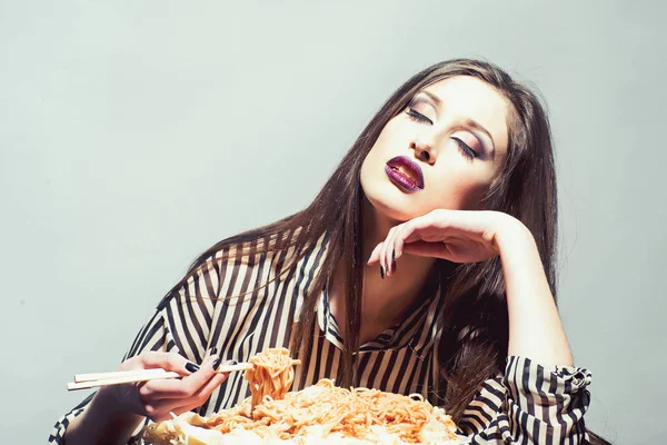 Kvinna äta spaghetti med ätpinnar. Kvinna äta pastarätt med tomatketchup — Stockfoto
