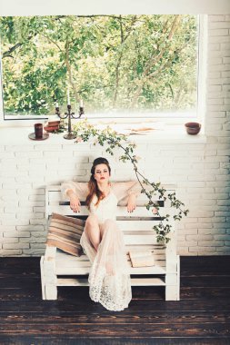 Romantik yazar adlı şiir kitabı. Güzellik ve moda vintage tarzı bak. Güzel kız beyaz gelinlik ve retro saç modeli. Moda kadın modeli kitap okumak. bahar ya da yaz kız bankta sakin ol