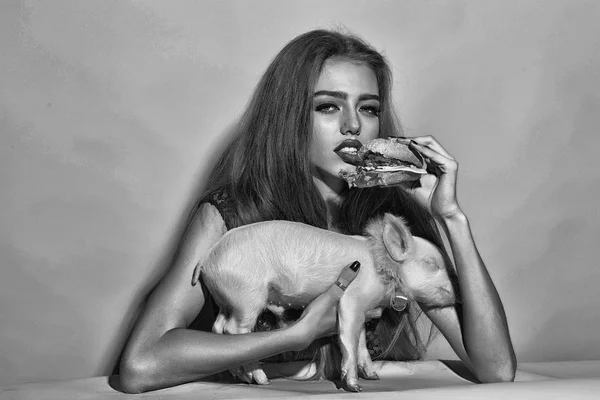 Kvinna med hamburgare och pigglet — Stockfoto