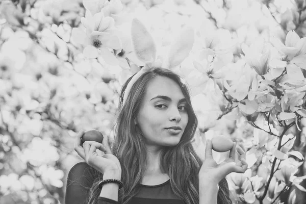 blossoming magnolia flowers and woman in bunny easter ears