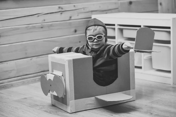 Petit garçon enfant jouer dans un avion en carton, l'enfance . — Photo