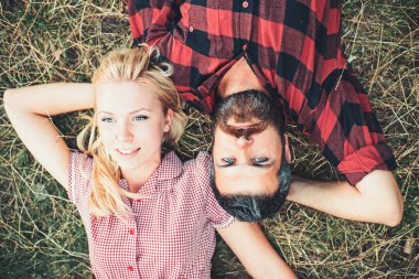 Romantik Çift parkta çim üzerinde yalan. Gençler bükülmüş kollar ile rahatlatıcı ve eller başlarını altında yukarıdan görüntüleyin. Yaz tatil Romantik