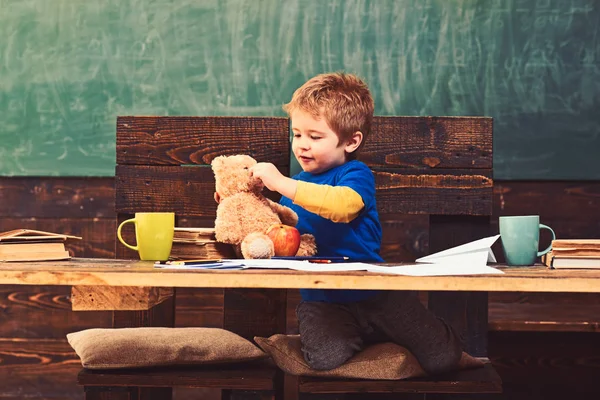 Маленький мальчик играет с плюшевым мишкой во время школьных каникул. Милый ребенок со своей любимой игрушкой. Образовательная игра в детском саду — стоковое фото