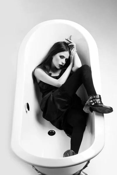 Vrouw in jurk met lang haar, zwarte lippenstift in bad — Stockfoto