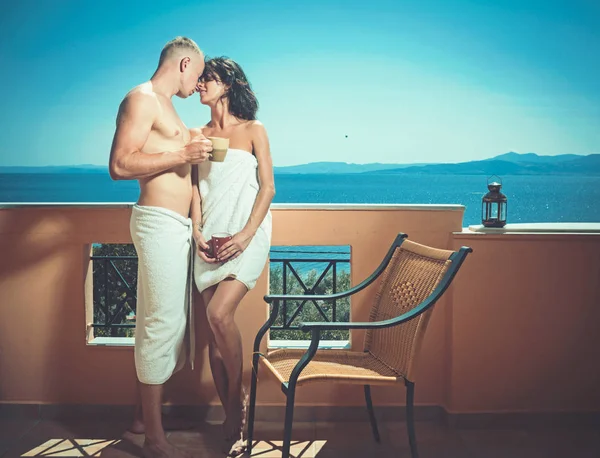 Ζευγάρι στην αγάπη πίνει καφέ στο μπαλκόνι. Πρωινή ώρα σέξι γυναίκα και άνδρα στο sea resort. Οικογένεια και ημέρα του Αγίου Βαλεντίνου. Καλοκαιρινές διακοπές και ταξίδια διακοπές. Αγαπούν τις σχέσεις του ζεύγους απολαμβάνοντας καφέ — Φωτογραφία Αρχείου
