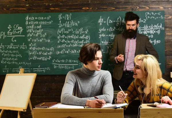 Estudiantes universitarios haciendo estudios en grupo. Estudiante adolescente preparándose para exámenes en el aula universitaria. Libros viejos sobre una mesa redonda de madera. Enseñar es la capacidad de compartir información . —  Fotos de Stock