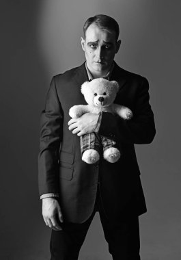 Yalnız ve depresyonda. Oyuncak ayı oyuncak dakika MIME dostum. Oyuncak Dükkanı MIME makyaj ile tiyatro oyuncusu. Üzücü duygular miming tiyatro oyuncusu. Mutsuz MIME sanatçı. Tiyatro performans sanatı ve pandomim drama