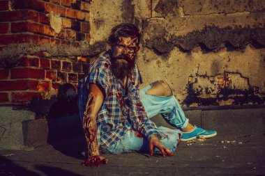 Zombi adam asfalt üzerinde oturur