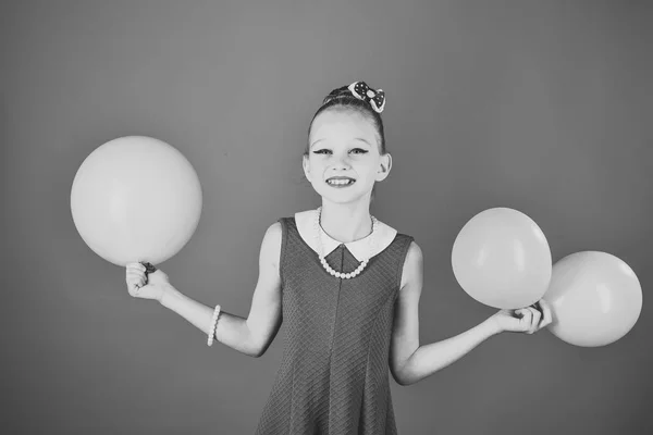 Belleza y moda, pasteles picantes. Niño con globos, cumpleaños. Niña pequeña con globos de fiesta, celebración. Cumpleaños, felicidad, infancia, mira. Niña con globos de retención de peinado . — Foto de Stock