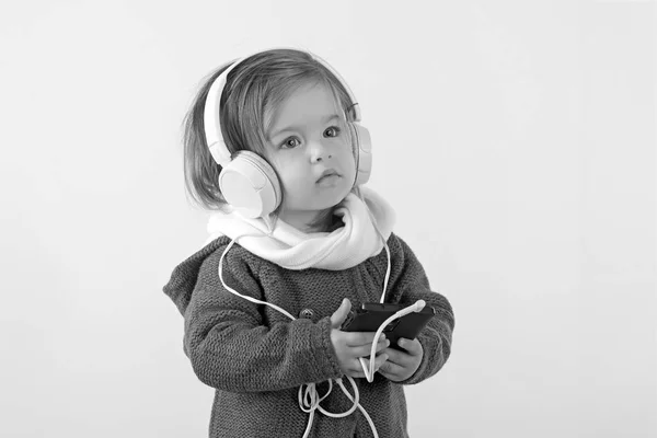 Infancia y felicidad. moda de invierno niño. divirtiéndose. Niña sonriendo. Pequeña chica feliz. Sentirse libre y feliz. niño escuchar música con auriculares y mp3 en el teléfono. Estilo otoño —  Fotos de Stock