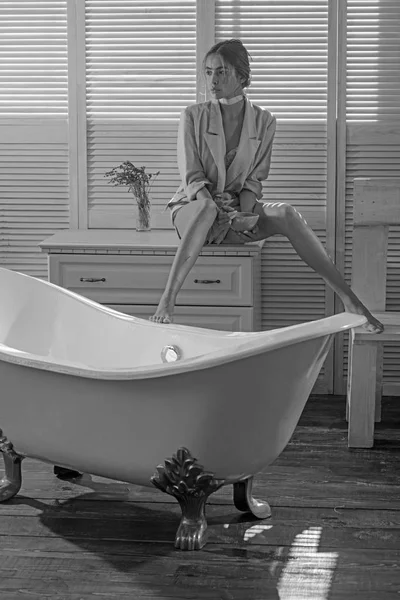 Una donna si siede sul cassetto in bagno. Donna di moda in giacca a bagno. Bellezza ragazza mangiare cibo da ciotola. Dieta per la salute e l'assistenza sanitaria — Foto Stock