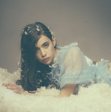 Pijama partisi için giyinmiş. Uyku giyim genç kadın. İyi uykular Pijama giyiyor. Güzel kızla tüy uzun saç ipek pijama. Sevimli kız kuş tüyü yatak yastık ve yatak üzerinde rahatlatıcı