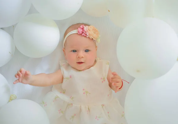 Lindo juguetón. Dulce bebé. Nueva vida y nacimiento. Felicidad infantil. Niña pequeña. Feliz cumpleaños. Familia. Cuidado de niños. Día de los niños. Retrato de niño feliz en globos blancos — Foto de Stock