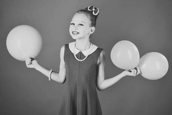 Schönheit und Mode, kraftvolle Pastelltöne. kleines Mädchen mit Party-Luftballons, Feier. Geburtstag, Glück, Kindheit, sieh an. Kind mit Luftballons, Geburtstag. Kleines Mädchen mit Frisur hält Luftballons. — Stockfoto