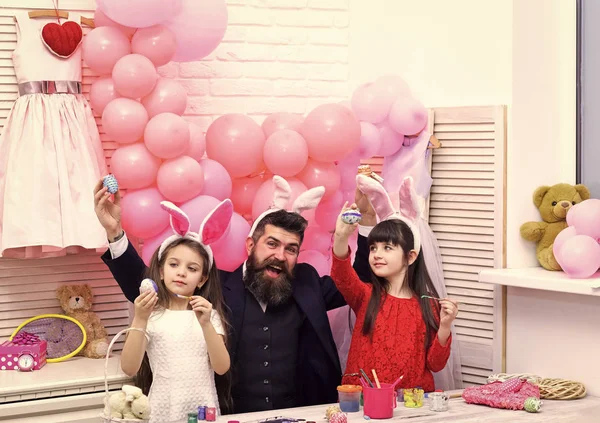 Easter, father and children in pink bunny ears.