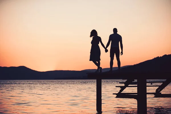 Romantický mladý pár na pláži na východ nebo západ slunce. — Stock fotografie
