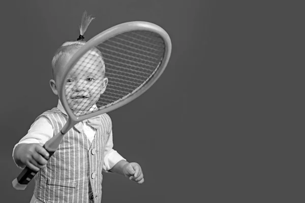 Cute and energetic. Little sport lover. Adorable little child with tennis racket. Active happy child. Small tennis player. Enjoying my favorite sport, copy space