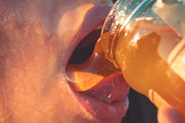 Μέλι στάζει στα χείλη σέξι κορίτσι. Τρώνε μέλι. Ομορφιά μοντέλο γυναίκα ανοιχτό στόμα, μοντέλο πίνοντας το νέκταρ. Έννοια υγιεινή διατροφή, δίαιτα, επιδόρπιο — Φωτογραφία Αρχείου