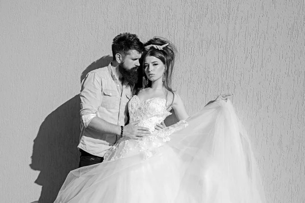 Fashion and romance. Sensual bride in white wedding dress. Bearded groom in casual wear. Man and woman of fashion. Romantic couple in love. Couple of lovers with fashion style