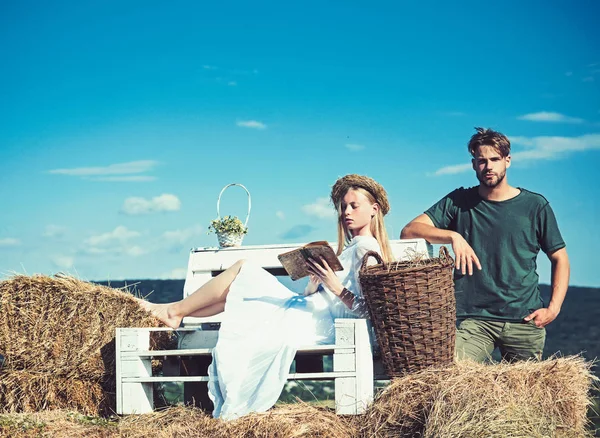 Couple in love on vacation. Woman bride in wedding dress relax on bench. Sensual woman read book for man. Family enjoy summer nature. Girlfriend and boyfriend date outdoor