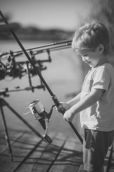 Sonrisa infantil con caña de pescar en muelle de madera —  Fotos de Stock