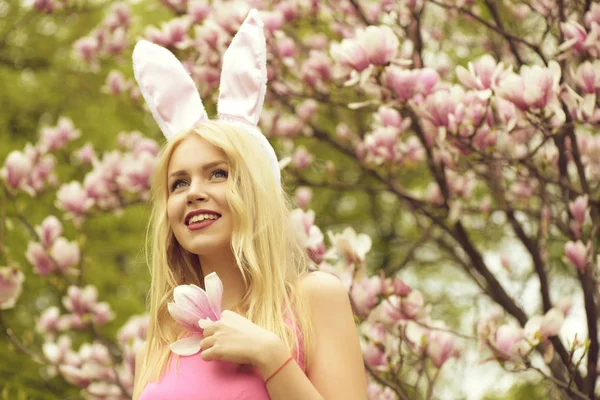 Meisje in bunny oren met magnolia tak — Stockfoto