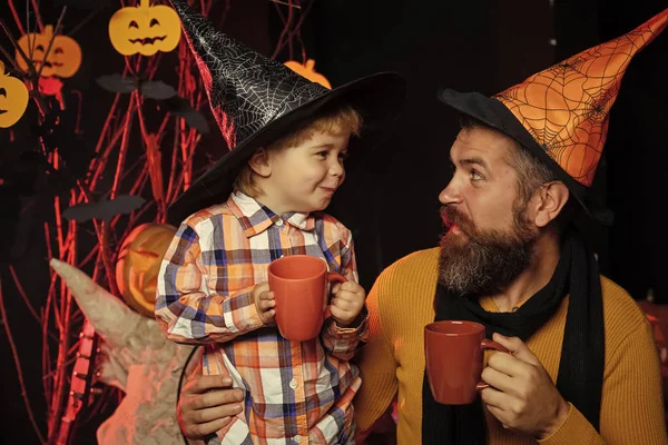 Halloween Boy kid with happy face and bearded man at pumpkin.