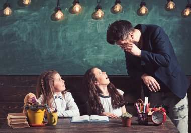 Sakallı adam ve küçük kız İlköğretim Okulu. Öğretmen kız öğrenciler sınıfta öğretmek. Çocuk öğrencilerimiz masa başında eğitim. Öğretmen ve öğrenciler, ders. Eğitim ve okul kavramı