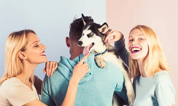 Hrát se svým psem pomoci mu jeho naplno žít. Šťastná rodina bavit s husky psa. Šťastné ženy a muži hrají s rodinný mazlíček. Přátelé s čistokrevná psí plemena. Domácí sedící péče o domácí zvíře — Stock fotografie