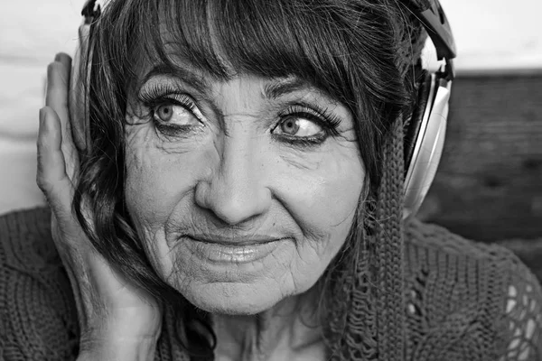 Vieille femme écouter de la musique dans les écouteurs . — Photo