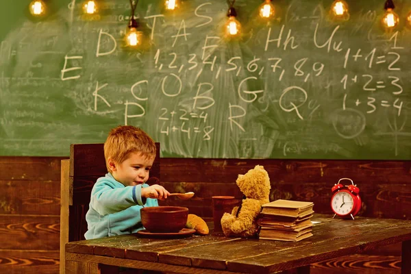 Concetto di alimentazione. Un orsacchiotto che nutre bambini a scuola. Ragazzo che nutre e si prende cura di un amico giocattolo in classe. Nutrire il cervello — Foto Stock