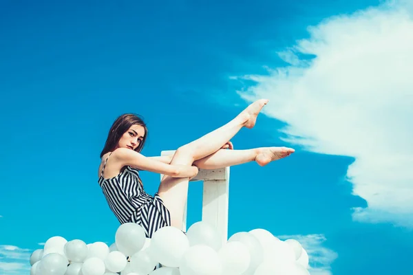 Чувствовать свободу и мечтать. вдохновение и воображение. Девушка сидит в небе. Модный портрет женщины. женщина в летнем платье с воздушными шарами для вечеринок. чувство свободы — стоковое фото