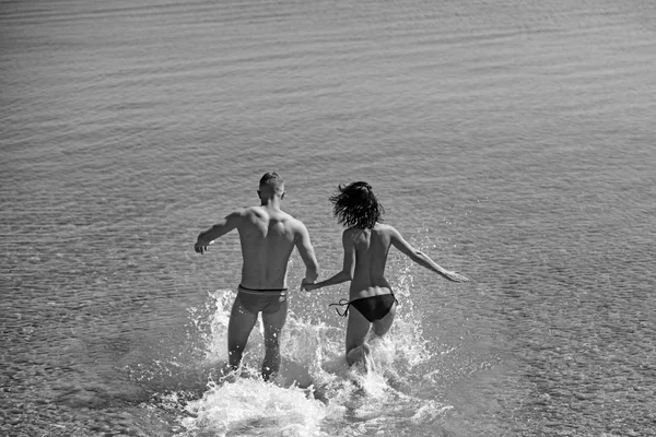 Έννοια του ευτυχία και αγάπη. ευτυχία του νεαρό ζευγάρι τρέχει στο θαλασσινό νερό. — Φωτογραφία Αρχείου