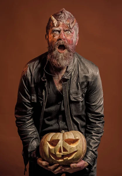Halloween satan with beard, wounds, red blood on surprised face