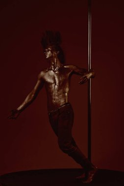 Güçlü dansçı egzersiz kutup. Özgürlük. Pole dans spor. Pilon üzerinde dans gümüş gövde sanat kaslı adam. Metal yüzey ile seksi maço. Atletik adam olun akrobatik öğeleri pilon üzerinde.