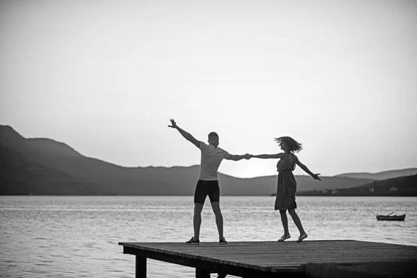 Menina e homem dançam na água do mar ao pôr-do-sol. menina e homem dançando no crepúsculo . — Fotografia de Stock