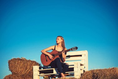Gitarist oynamak akustik gitar ahşap Bank güneşli üzerinde açık. Gitarist gerçekleştirmek müzik konser mavi gökyüzü