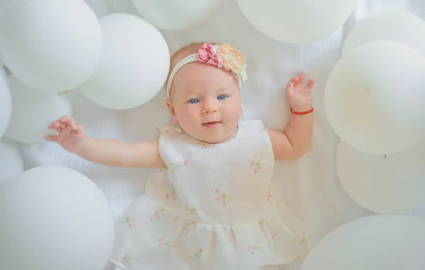 Χαρούμενα cutie. Οικογένεια. Φροντίδα των παιδιών. Παιδική την ημέρα. Γλυκό μωράκι. Νέα ζωή και τη γέννηση. Πορτραίτο του ευτυχισμένο παιδάκι στα λευκά μπαλόνια. Μικρό κορίτσι. Να τα εκατοστήσεις. Παιδική ευτυχία — Φωτογραφία Αρχείου