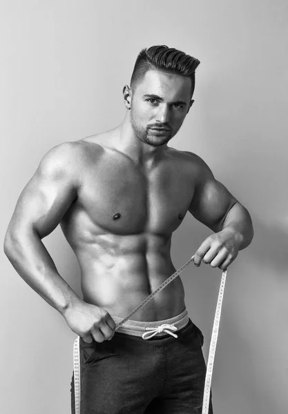 Muscular hombre con cinta métrica — Foto de Stock