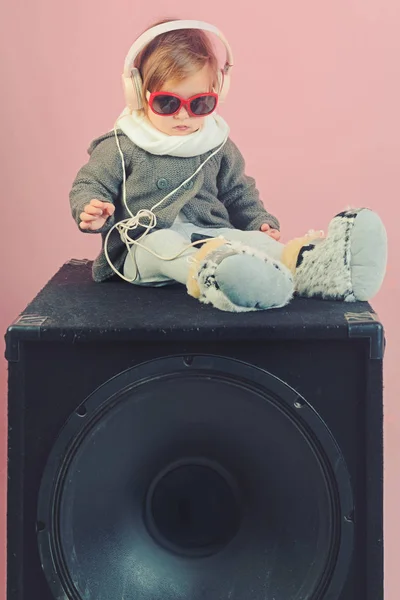 kid listen music with headset and mp3 on phone. childhood and happiness. Hip hop girl. little girl child smiling. winter kid fashion. having fun. small happy girl. audio speaker. Beautiful female