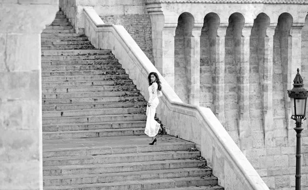 时尚新娘穿着白色婚纱在楼梯上。时尚模特在楼梯台阶上长头发, 婚礼 — 图库照片