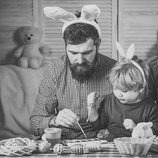 Father and son paint handmade egg.