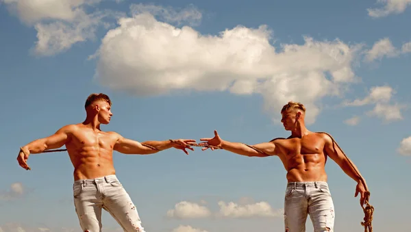 Den Sieg anzufechten. kräftige Männer ziehen Seil mit muskulöser Handkraft. Männer zeigen ihre Stärke gegen Mitbewerber. Zwillinge Konkurrenten mit muskulösen Körpern. Sportliche Zwillinge auf der Gegenseite — Stockfoto