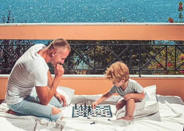 Father with son on balcony play chess. father and son have good time together. — Stock Photo, Image