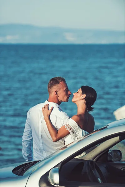 家族とバレンタインの日。セクシーな女と車の近くに海の男。一緒に夏の日を楽しんでいるカップルの関係が大好きです。愛のカップルは、道路の旅の後リラックスします。夏の休日や休暇旅行 — ストック写真