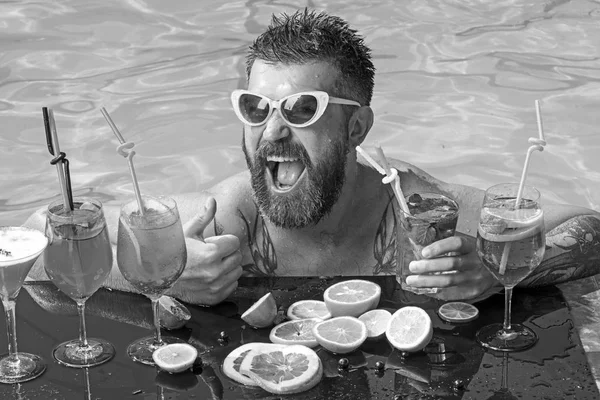 Odpočiňte si v moři a spa resort. Muž koupání a pití alkoholu. Letní dovolená v Miami nebo Maledivy. Bazénová party, vitamín a diety. Koktejl s ovocem na vousatý muž v bazénu. — Stock fotografie