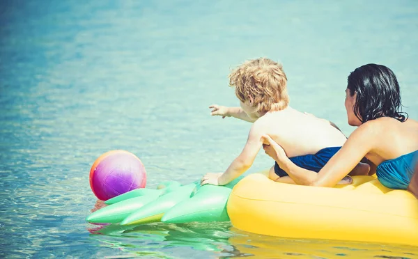 Mujer con niño nadar en colchón de aire amarillo en el agua en el verano . —  Fotos de Stock