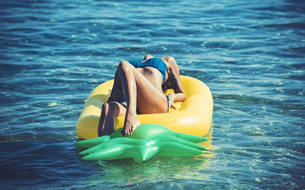 Style de vie estival d'une jolie fille gaie nageant sur un matelas gonflable dans l'océan, portant un bikini — Photo
