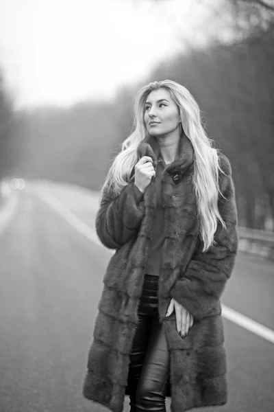 Femme sexy en manteau de fourrure. Voyage et voyage d'affaires ou auto-stop. femme de luxe avec de longs cheveux blonds — Photo